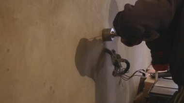 Bir sondaj makinesi ve duvarda delik delme kullanarak alt