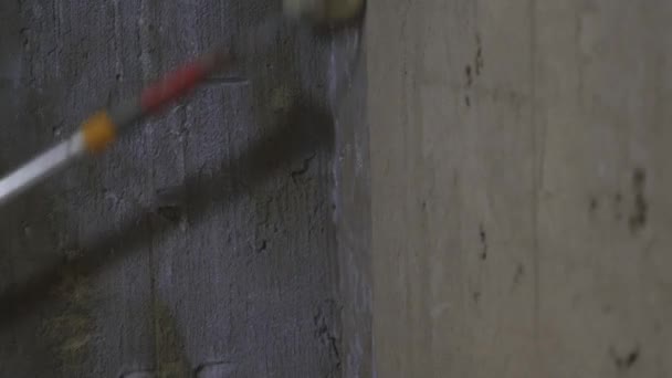 Reparatiewerk, priming en schilderen de kale betonnen muur met witte verf, witte primer met een roller of borstel, plafond borstels. — Stockvideo