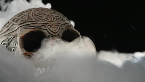 頭蓋骨は、暗い背景に煙で覆われています。 — ストック動画