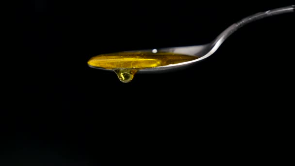 Honey Flowing from Spoon against Black Background — Stock Video