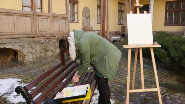Ung konstnär tränger ut färg på paletten — Stockvideo