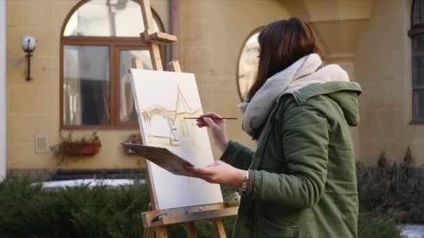 Jóvenes artistas dibujan en la ciudad. Artistas pintando cuadros en la calle. Los estudiantes pintan la construcción de la vieja ciudad europea — Vídeos de Stock