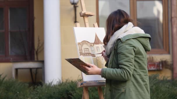 De jeunes artistes dessinent dans la ville. Artistes peinture tableau dans la rue. Les étudiants peignent la construction de la vieille ville européenne — Video