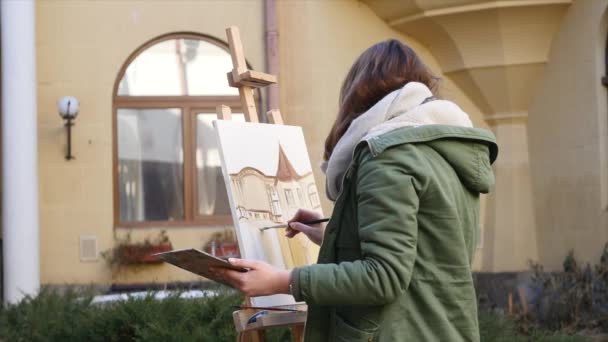 Giovani artisti disegnano in città. Artisti che dipingono quadri per strada. Gli studenti dipingono la costruzione della vecchia città europea — Video Stock