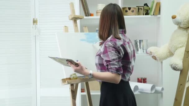 Artis datang ke gambar dan mulai cat minyak di studio cerah. Gambar seniman laki-laki kreatif dengan cat minyak di studio — Stok Video