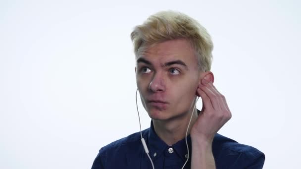 Fiatal jóképű férfi, éneklés, tánc, olvasás fejhallgató fehér háttérhez képest — Stock videók