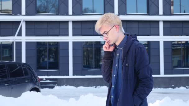 Knappe jonge man spreken op een mobiele telefoon op de straat van de grote stad — Stockvideo