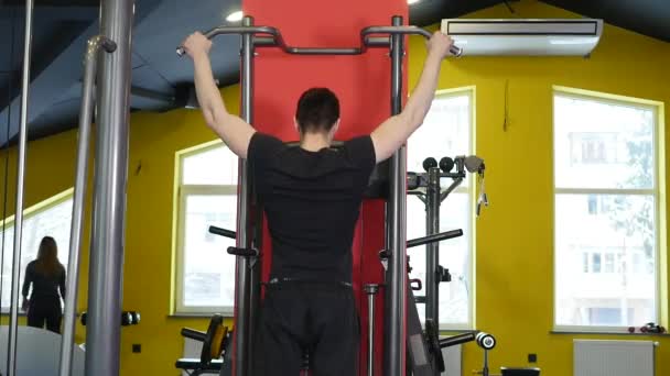 Göğsüne simülatör fitness odasında oturan genç adam sallıyor — Stok video