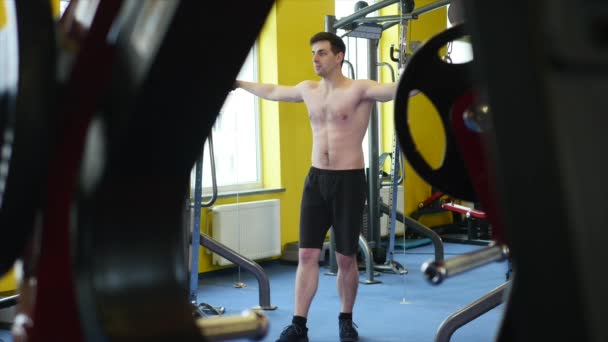 Bodybuilder kerel in sportschool oppompen van handen close-up — Stockvideo