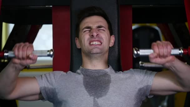Muž s sportovní postava dělá cvičení na trenažéru v tělocvičně — Stock video