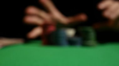 Ağır çekimde bir Poker fişleri atma adam close-Up. Siyah arka plan üzerine kumar cips atma el close-up. Poker oyuncusu belirteçleri oyun masa üstüne atma onun hisselerini artan