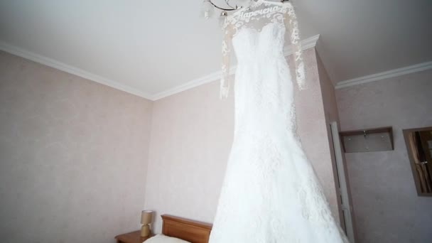 Brides dress hanging on a lamp, wedding dress in brides room, White wedding dress hanging — Stock Video