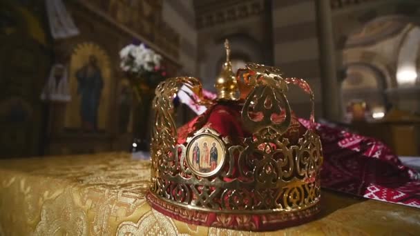 Atributos da igreja para cerimônia de casamento. Coroas de ouro estão no altar. Atributos do padre. Interior da igreja — Vídeo de Stock