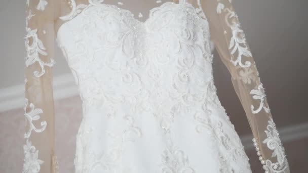 Brautkleid hängt an einer Lampe, Hochzeitskleid im Bräutelzimmer, weißes Hochzeitskleid hängt — Stockvideo