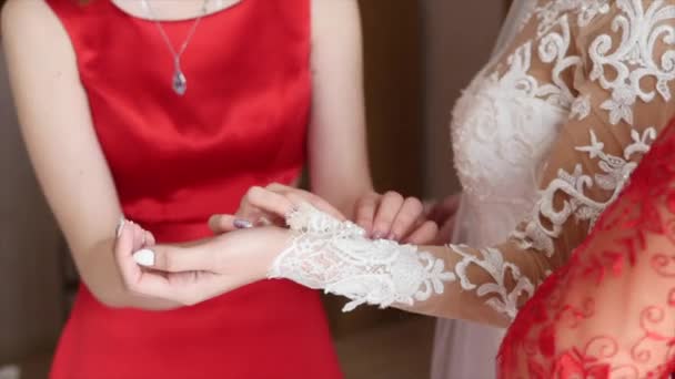 Brudtärna hjälper bruden att bära klänning — Stockvideo