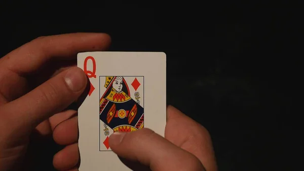 Speelkaarten in de hand geïsoleerd op zwarte achtergrond — Stockfoto