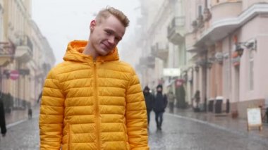 Genç yakışıklı adam kameraya poz utangaç ama yine de o fotoğraf manken olmak ve gülümsemeye çalışır