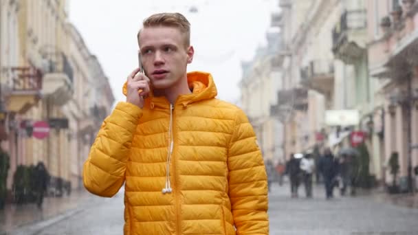 Um jovem estudante conversa com o telefone na rua de inverno na Europa — Vídeo de Stock