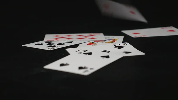 A jogar às cartas. Jogando cartas caindo na mesa preta — Fotografia de Stock