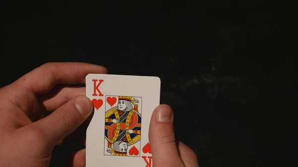 Spelkort i hand isolerad på svart bakgrund — Stockfoto
