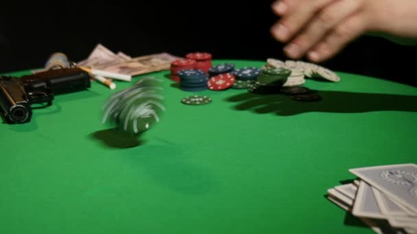Μεγέθυνση του ανθρώπου που ρίχνει μια μάρκες πόκερ σε αργή κίνηση. Γκρο πλαν του χεριού με ρίψη τυχερών παιχνιδιών μάρκες σε μαύρο φόντο. Αύξηση του πονταρίσματος ρίχνοντας τις μάρκες στο τραπέζι παιχνιδιού παίκτη του πόκερ — Αρχείο Βίντεο