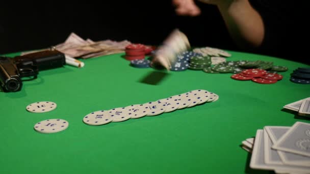 Detail člověka házení pokerové žetony ve zpomaleném filmu. Detail ruční s házením hracích známek na černém pozadí. Pokerový hráč zvyšuje jeho sázky házet žetony na herní stůl