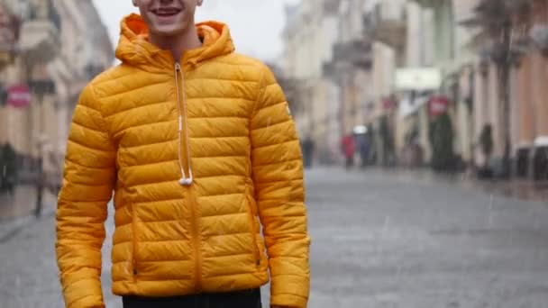 Glimlachende man in de straat verschijnt duimen. de sneeuw valt op de achtergrond — Stockvideo