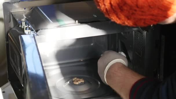 Молодой ремонтник чинит и ремонтирует микроволновую печь — стоковое видео