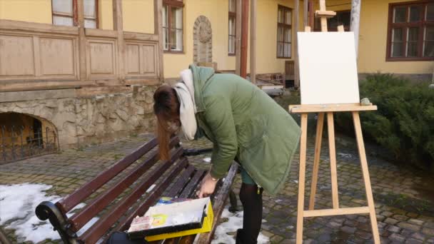 Νεαρός καλλιτέχνης συμπιέζει έξω χρώμα στην παλέτα — Αρχείο Βίντεο