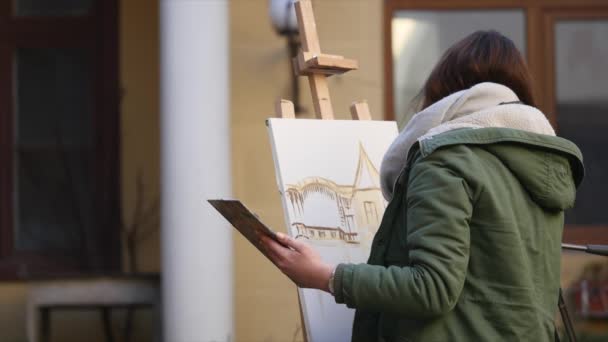 Jonge kunstenaars tekenen in de stad. Kunstenaars schilderen foto op straat. Studenten schilderen gebouw van de oude Europese stad — Stockvideo