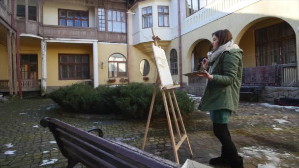 Junge Künstler ziehen in die Stadt. Künstler malen Bild auf der Straße. Studenten malen Gebäude der alten europäischen Stadt — Stockvideo