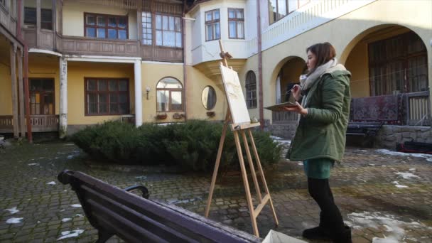 Giovani artisti disegnano in città. Artisti che dipingono quadri per strada. Gli studenti dipingono la costruzione della vecchia città europea — Video Stock