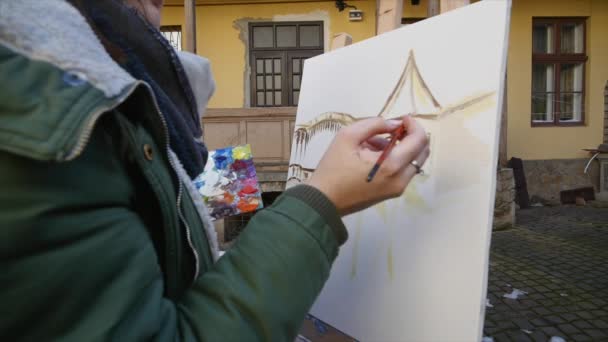Ragazza artista pittura a mano nella vecchia strada della città — Video Stock