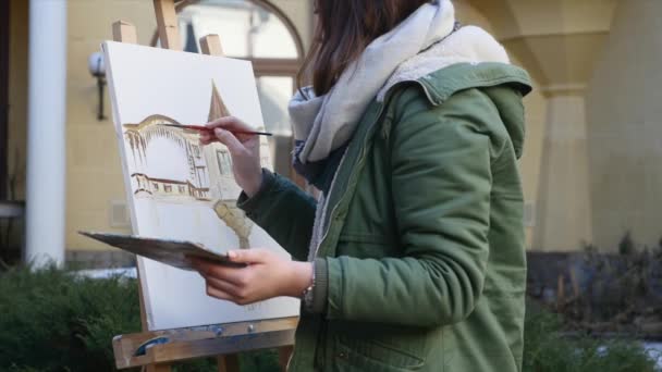 Jóvenes artistas dibujan en la ciudad. Artistas pintando cuadros en la calle. Los estudiantes pintan la construcción de la vieja ciudad europea — Vídeos de Stock