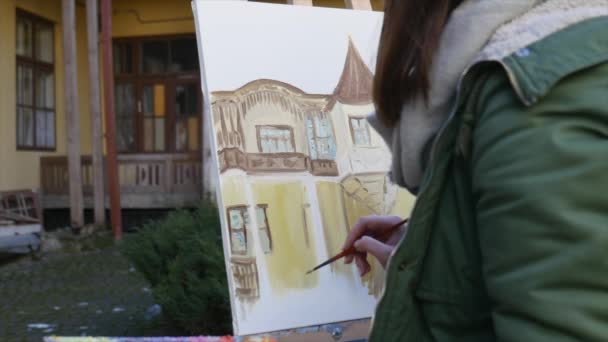 De jeunes artistes dessinent dans la ville. Artistes peinture tableau dans la rue. Les étudiants peignent la construction de la vieille ville européenne — Video