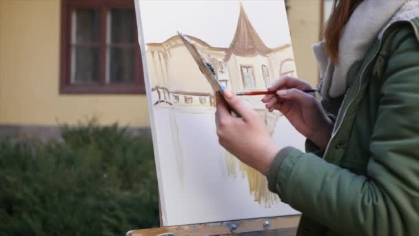 Ragazza artista pittura a mano nella vecchia strada della città — Video Stock