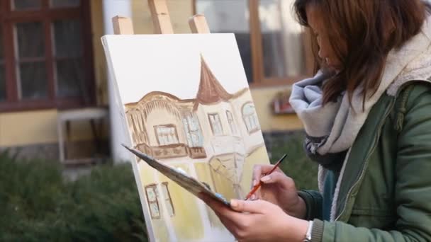 Dívka umělec ručně malované v staré město ulice — Stock video