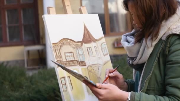 Meisje kunstenaar hand schilderij in oude straat — Stockvideo