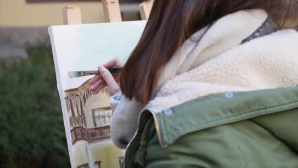 Meisje kunstenaar hand schilderij in oude straat — Stockvideo