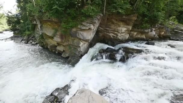 Egy folyó folyik át ezt a gyönyörű jelenetet, a hegyekben sziklák. lassú mozgás — Stock videók