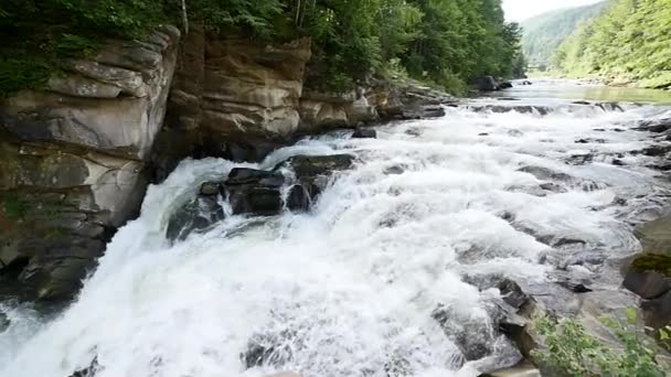 Egy folyó folyik át ezt a gyönyörű jelenetet, a hegyekben sziklák. lassú mozgás — Stock videók