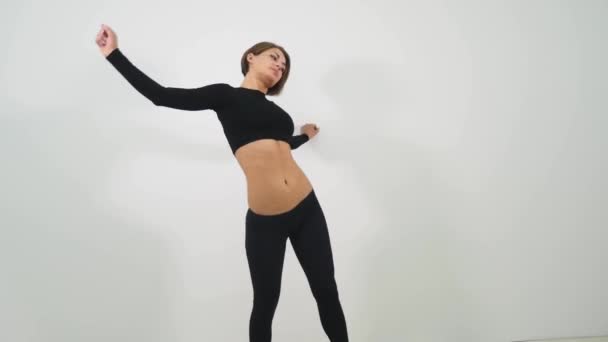 Joven mujer bailando sexy pole dance sobre fondo blanco — Vídeo de stock