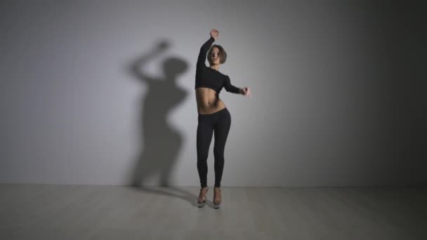 Fiatal, vékony szexi szőke pole dance nő gyakorlása stúdióban. . Vonzó szexi nő rúd táncos előadás szürke háttér — Stock videók