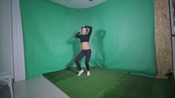 Sexy chica hace elemento en pole dance en verde fondo — Vídeos de Stock