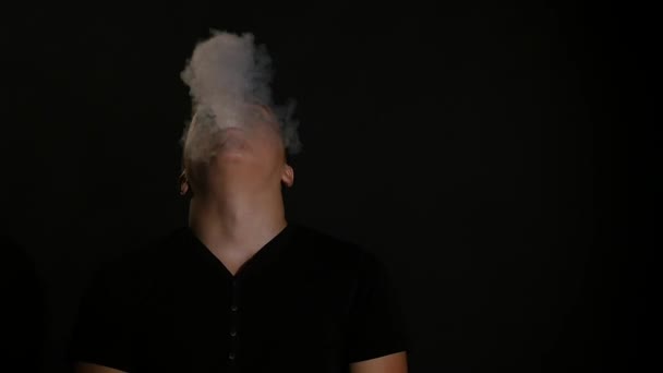 Man smoking electronic cigarette vapor on black background — Stock Video