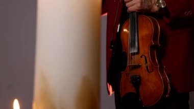 Mum siyah zemin üzerine intstrument oynarken keman çalar