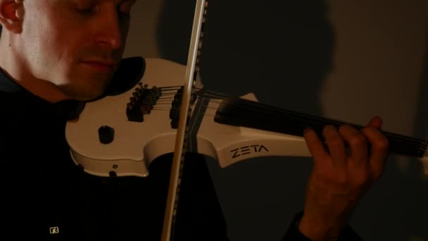 Βιολιστής άνθρωπος παίζει βιολί σε μαύρο φόντο. Κοντινό πλάνο — Αρχείο Βίντεο