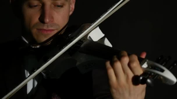 Скрипаль грає на скрипці на чорному тлі. крупним планом — стокове відео