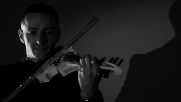Young man playing violin in dark room — Stock Video