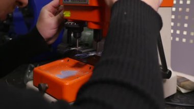 Anahtarları imalatı. Anahtarın bir kopyasını yapmak. Sihirbaz üstünde belgili tanımlık makine.